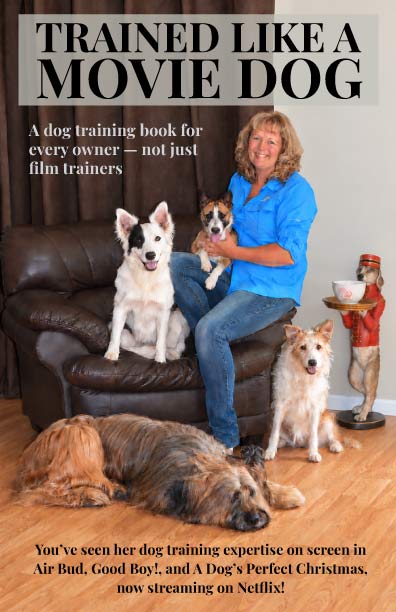 Trained Like a Movie Dog book cover: Bonnie Judd sitting with five of her trained dogs. A dog training book for every owner, not just film trainers.